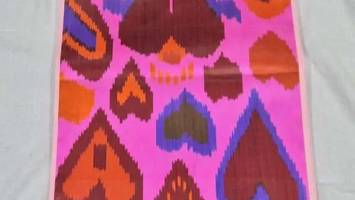 Ikat-Bahn in Pink und Orange mit herzförmigen Motiven, längs ausgelegt